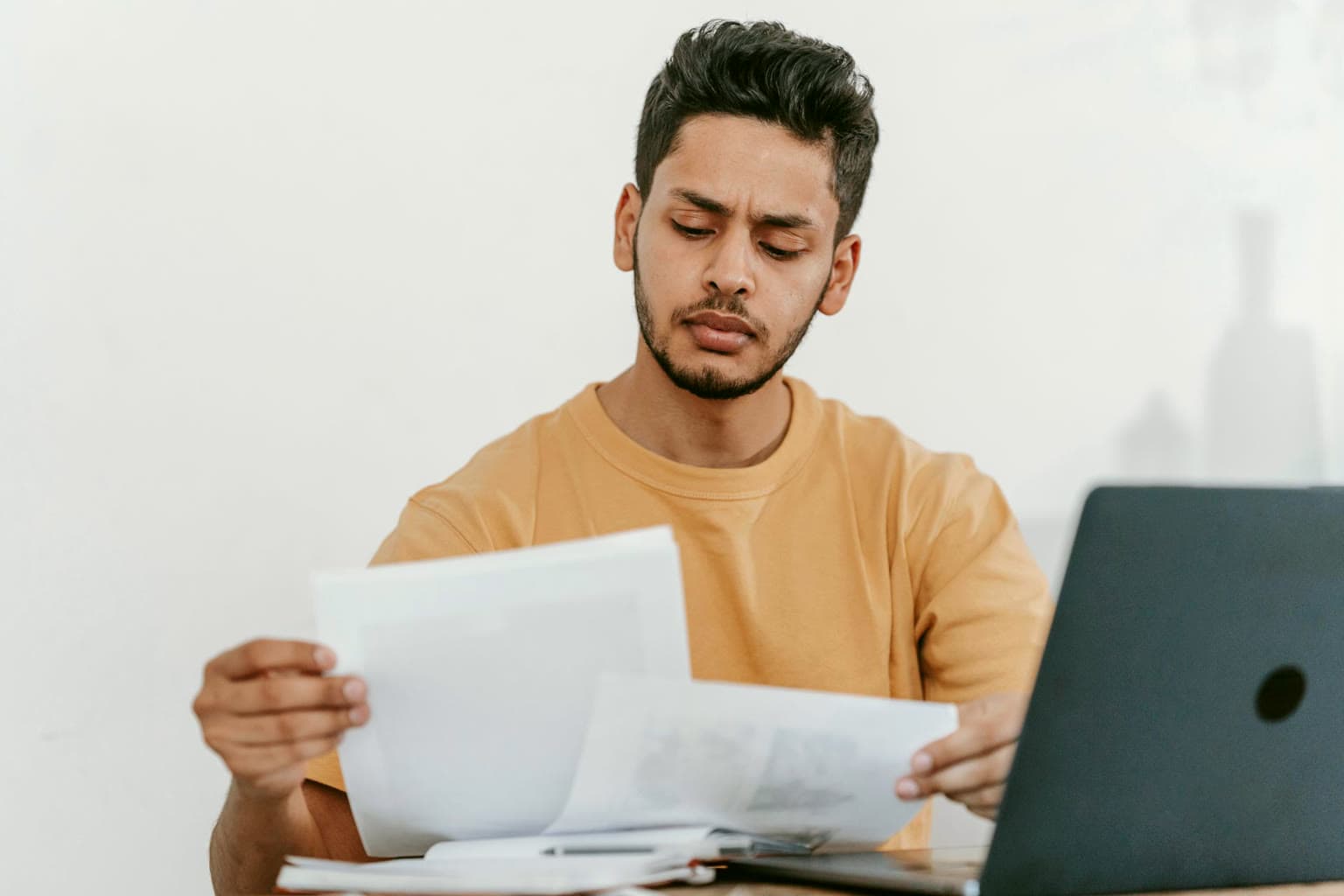 Business owner reviewing papers at a laptop